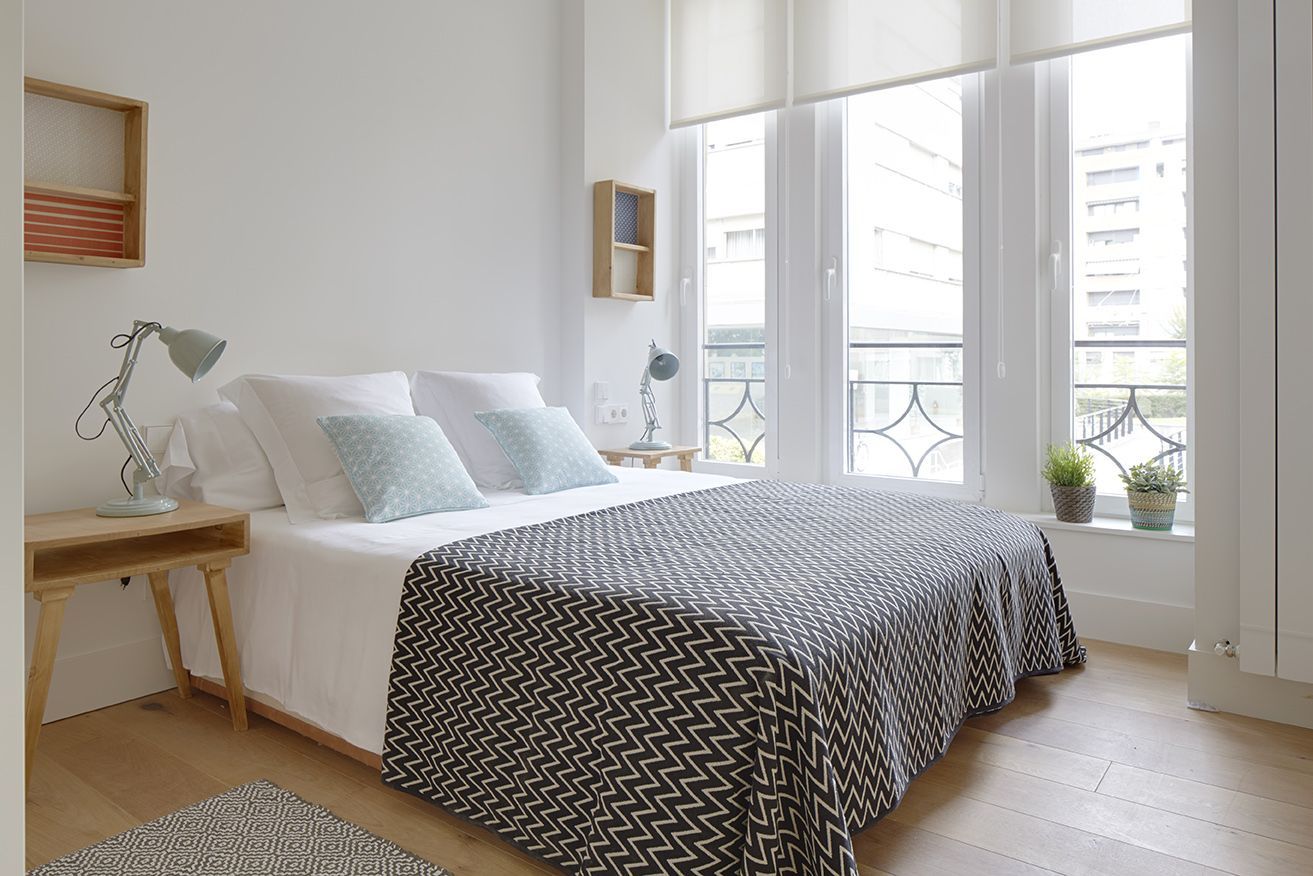 Segundo dormitorio con cama doble y grandes ventanales